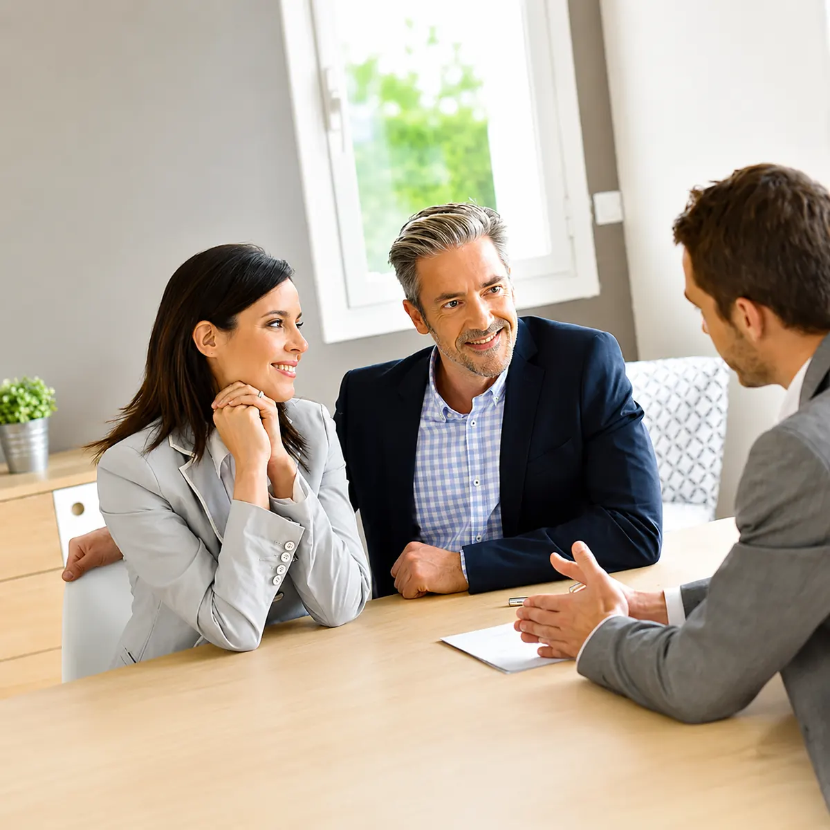 Couple souriant en rendez-vous avec un conseiller BNP PARIBAS pour un financement professionnel